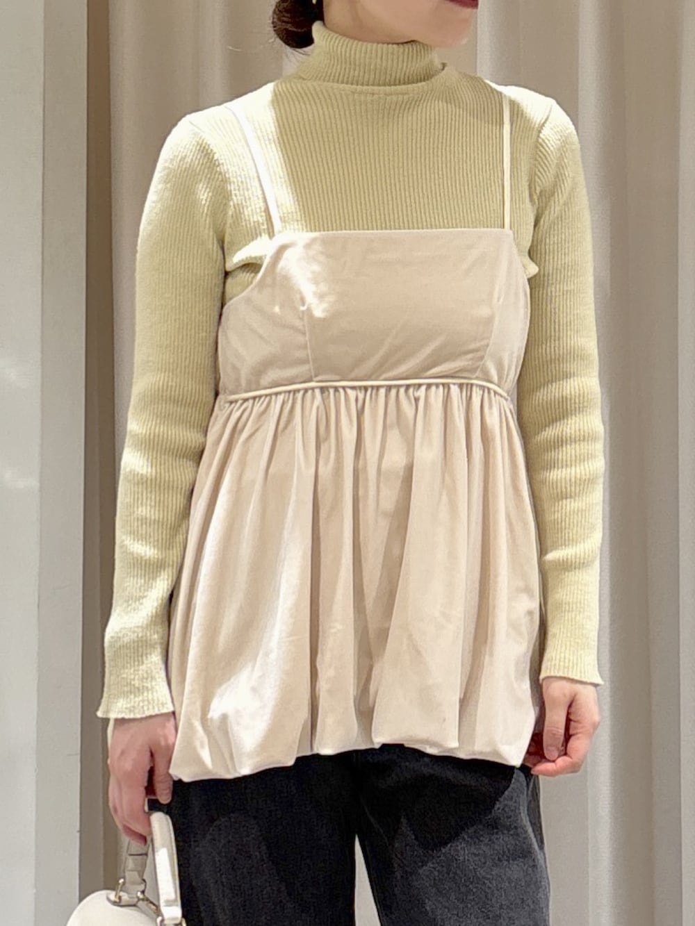 イエロー系のニット/セーター、ホワイト系のトートバッグ、ブラック系のデニムパンツを着用したレディースの秋コーディネートの4枚目の写真