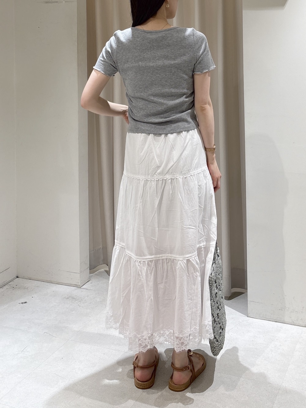 グレー系のTシャツ/カットソー、ホワイト系のスカート、ベージュ系のサンダルを着用したレディースの夏コーディネートの3枚目の写真