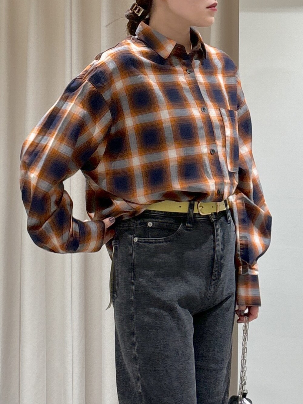 オレンジ系のシャツ/ブラウス、ブラック系のキャミソール、ブラック系のデニムパンツを着用したレディースの秋コーディネートの2枚目の写真