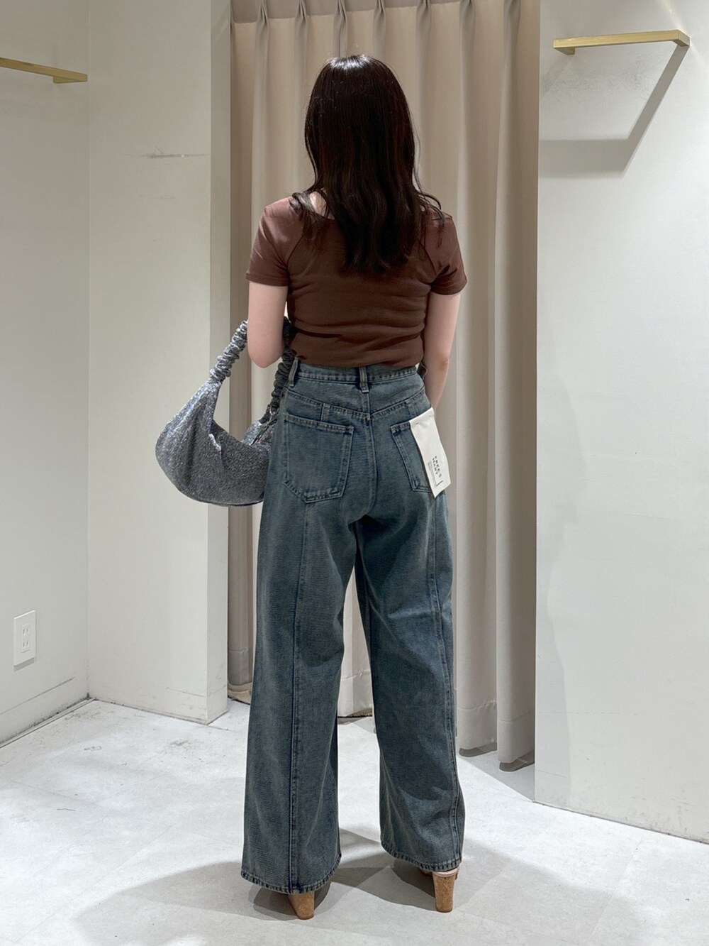 ブラウン系のTシャツ/カットソー、ブルー系のデニムパンツ、シルバー系のハンドバッグを着用したレディースの夏コーディネートの4枚目の写真