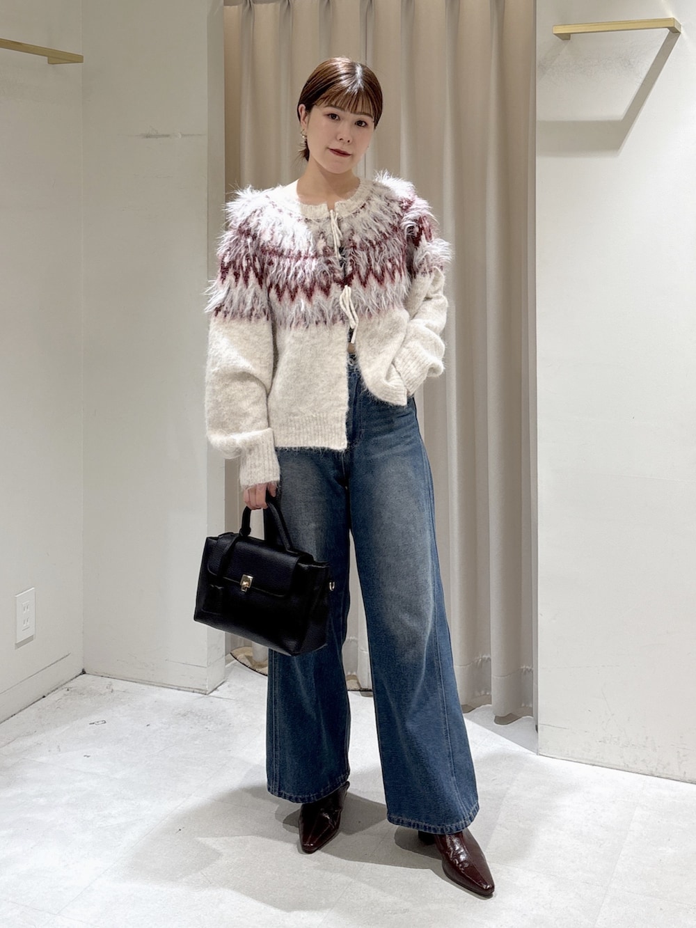 ホワイト系のニット/セーター、ブルー系のデニムパンツ、ブラウン系のパンプスを着用したレディースの秋コーディネートの3枚目の写真