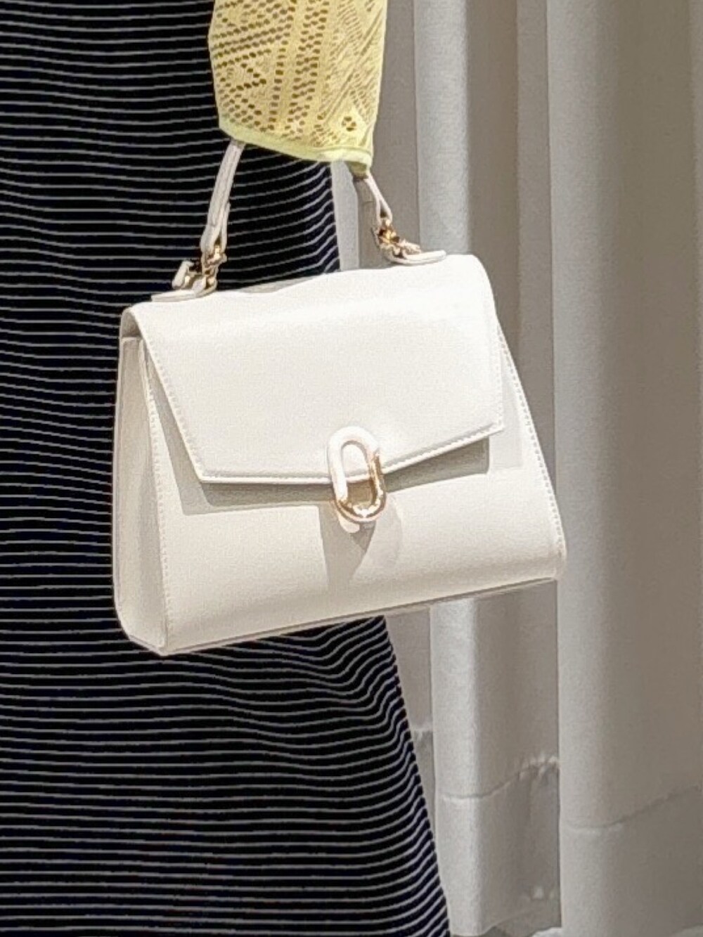 イエロー系のカーディガン/ボレロ、ブラック系のワンピース、ホワイト系のショルダーバッグを着用したレディースの夏コーディネートの5枚目の写真