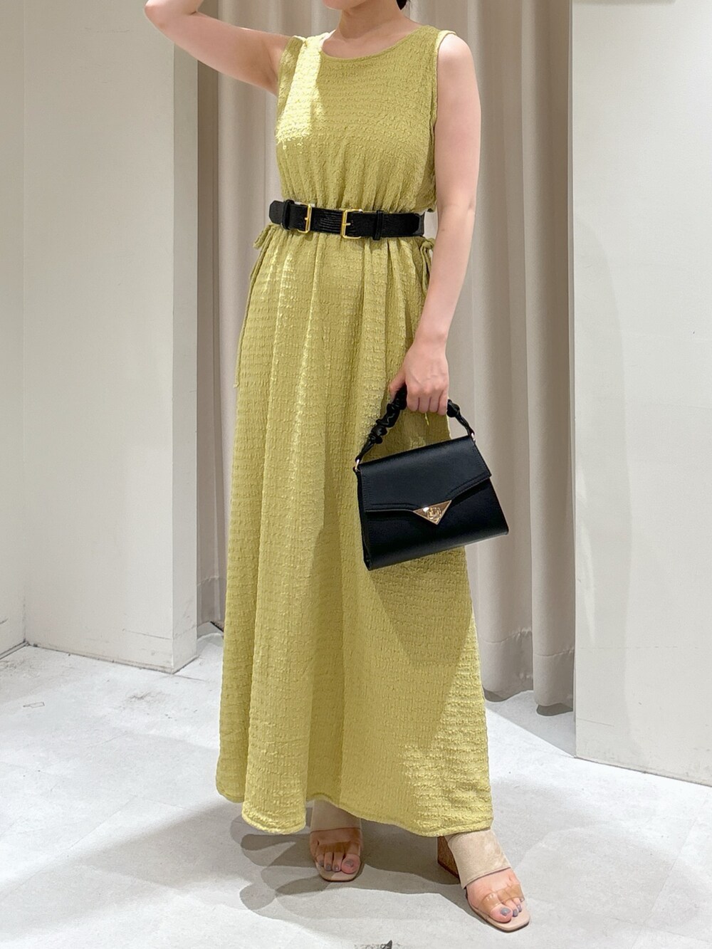 イエロー系のワンピース、ブラック系のショルダーバッグ、グレー系のサンダルを着用したレディースの夏コーディネートの7枚目の写真