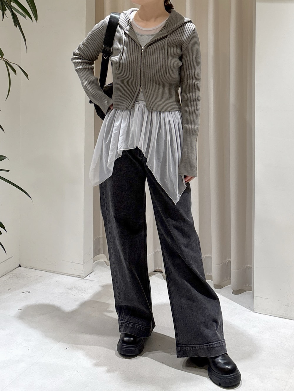 ブラウン系のニット/セーター、グレー系のTシャツ/カットソー、ブラック系のデニムパンツを着用したレディースの秋コーディネートの3枚目の写真