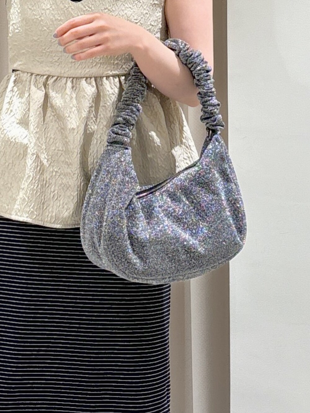 ホワイト系のシャツ/ブラウス、ブラック系のサンダル、シルバー系のハンドバッグを着用したレディースの春コーディネートの5枚目の写真