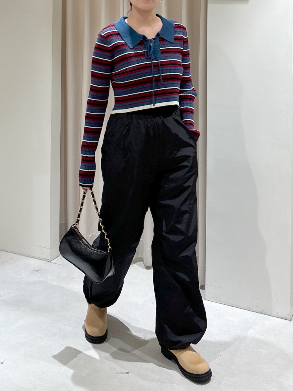 ブルー系のニット/セーター、ブラック系のトートバッグ、ベージュ系のブーツを着用したレディースの秋コーディネートの3枚目の写真