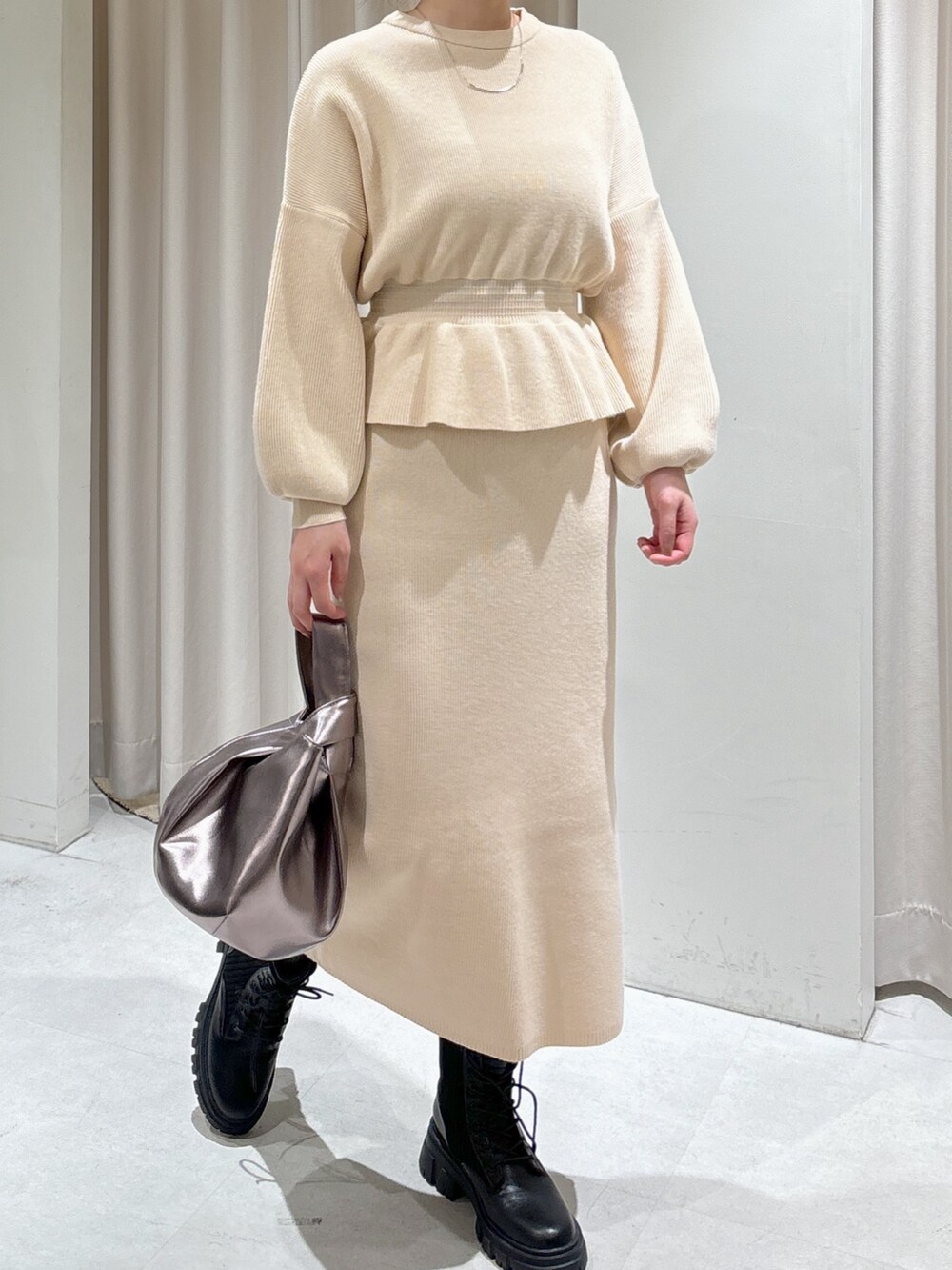 ホワイト系のワンピース、シルバー系のハンドバッグ、ブラック系のブーツを着用したレディースの秋コーディネートの3枚目の写真