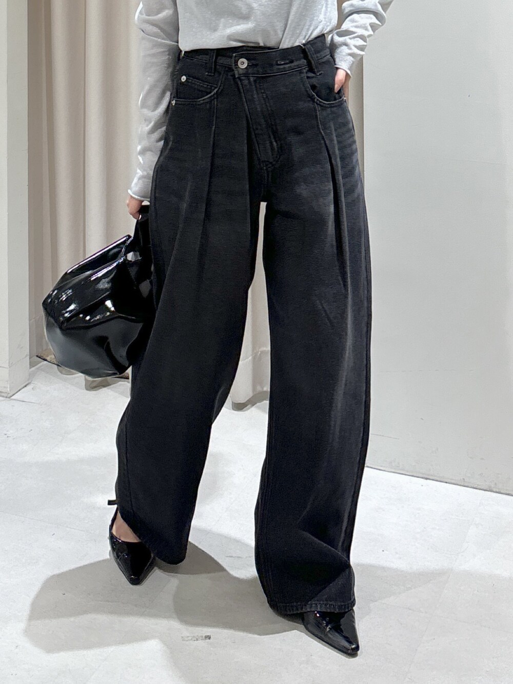 グリーン系のニット/セーター、グレー系のTシャツ/カットソー、ブラック系のハンドバッグを着用したレディースの秋コーディネートの7枚目の写真