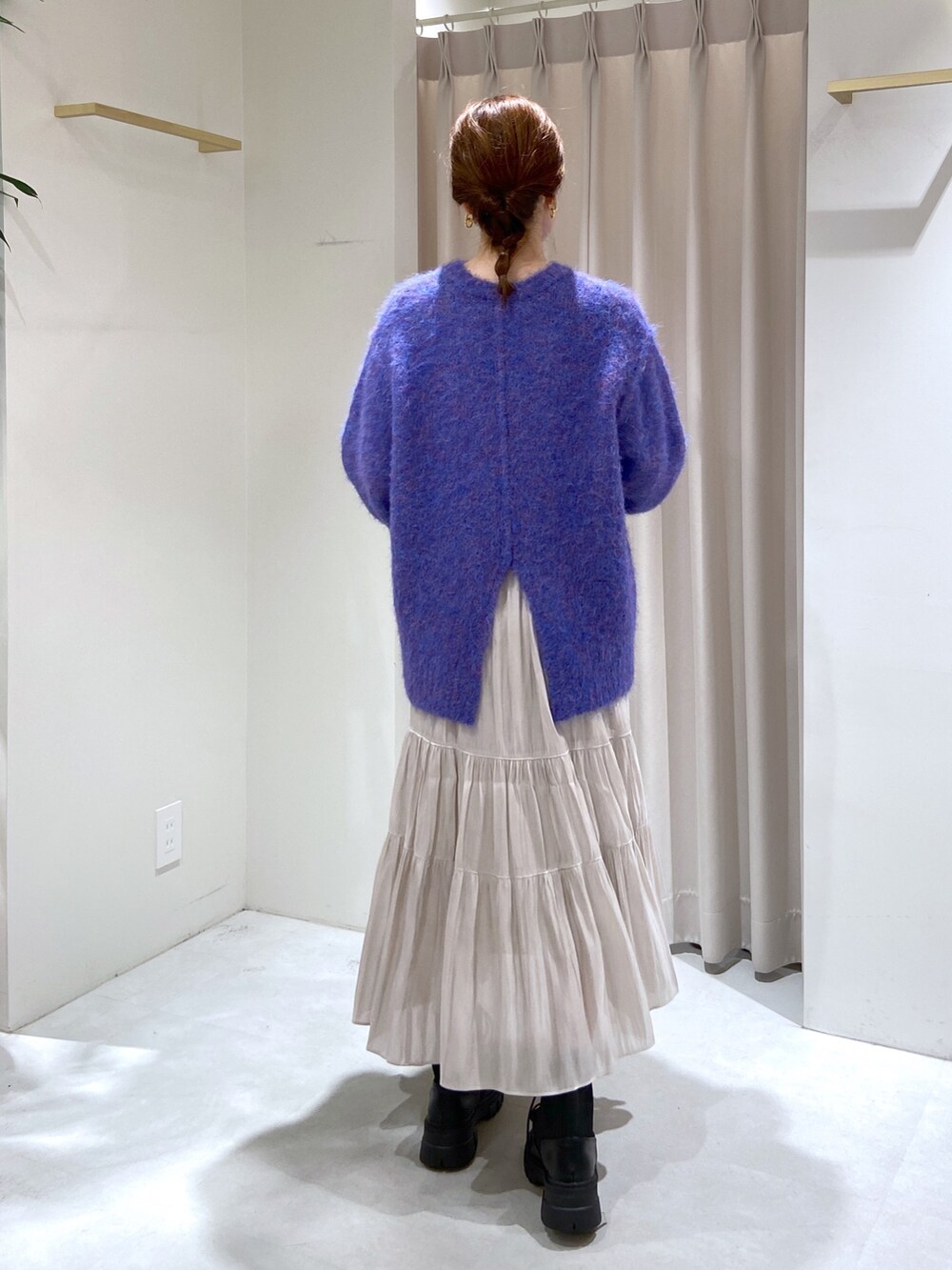 ブルー系のニット/セーター、ベージュ系のショルダーバッグ、ブラック系のブーツを着用したレディースの秋コーディネートの3枚目の写真