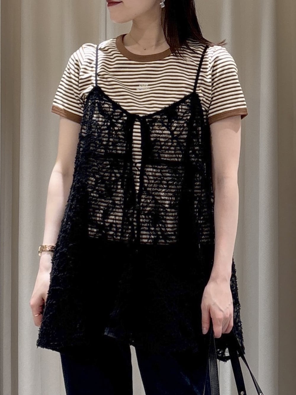 ブラック系のキャミソール、ブラウン系のTシャツ/カットソー、ブラック系のショルダーバッグを着用したレディースの春コーディネートの4枚目の写真