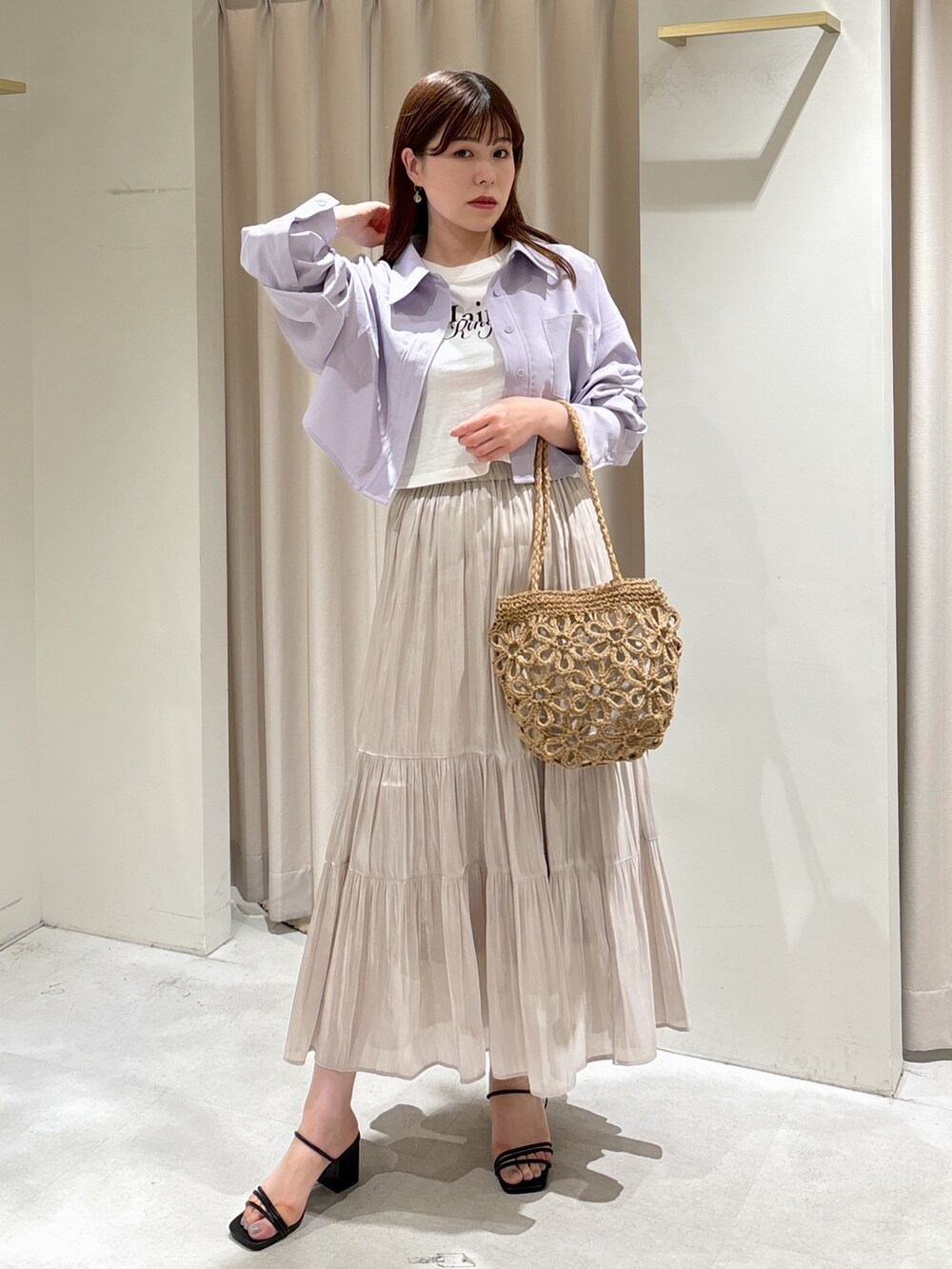 パープル系のシャツ/ブラウス、ホワイト系のTシャツ/カットソー、ベージュ系のかごバッグを着用したレディースの夏コーディネートの2枚目の写真