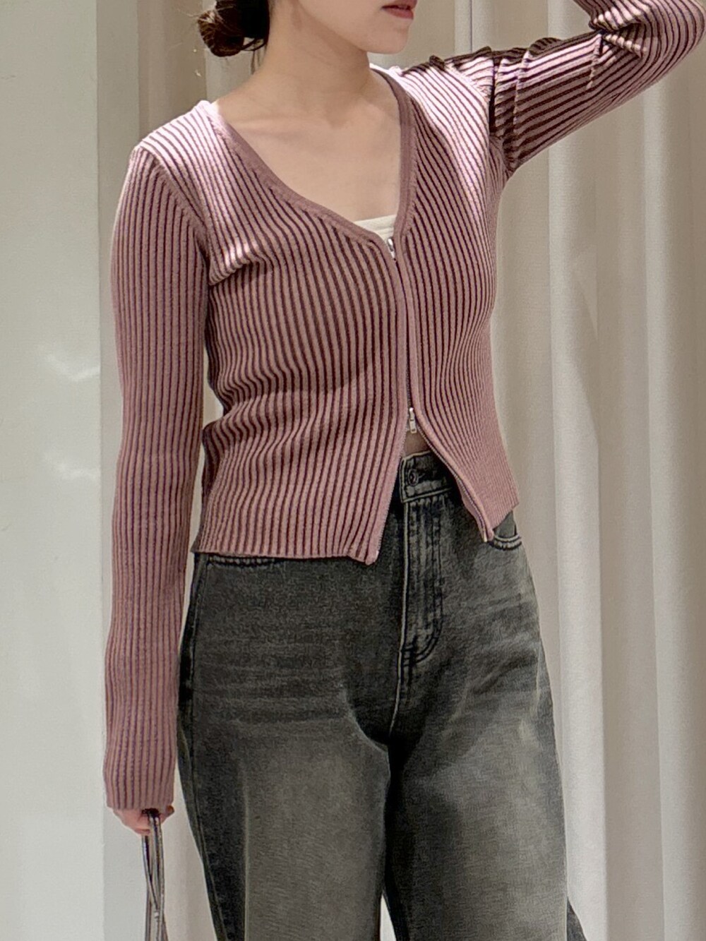 ピンク系のニット/セーター、ホワイト系のキャミソール、ベージュ系のショルダーバッグを着用したレディースの冬コーディネートの5枚目の写真