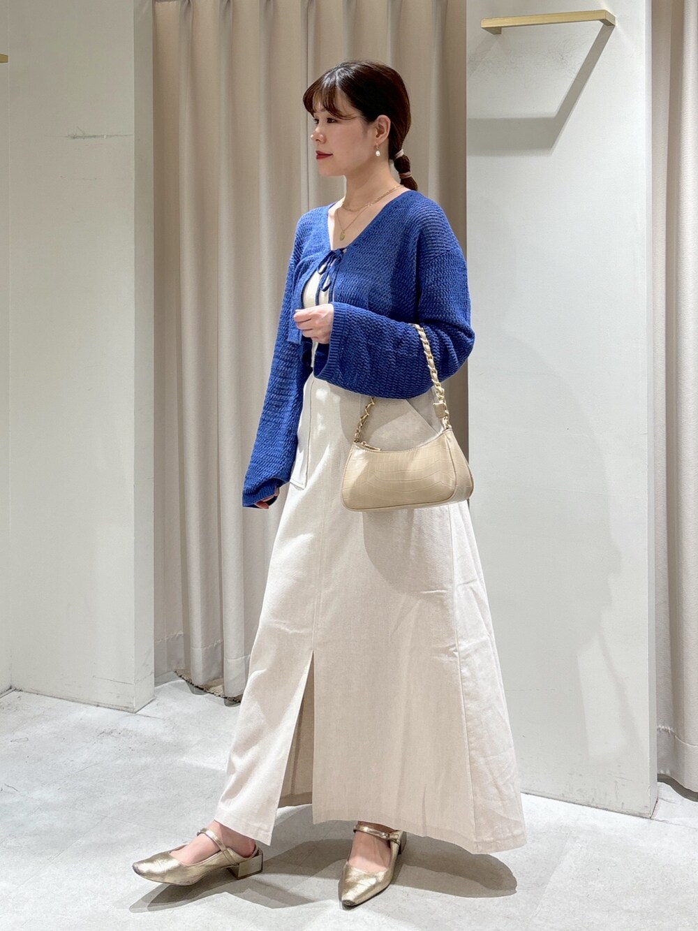 ブルー系のカーディガン/ボレロ、ホワイト系のキャミソール、ベージュ系のトートバッグを着用したレディースの夏コーディネートの2枚目の写真