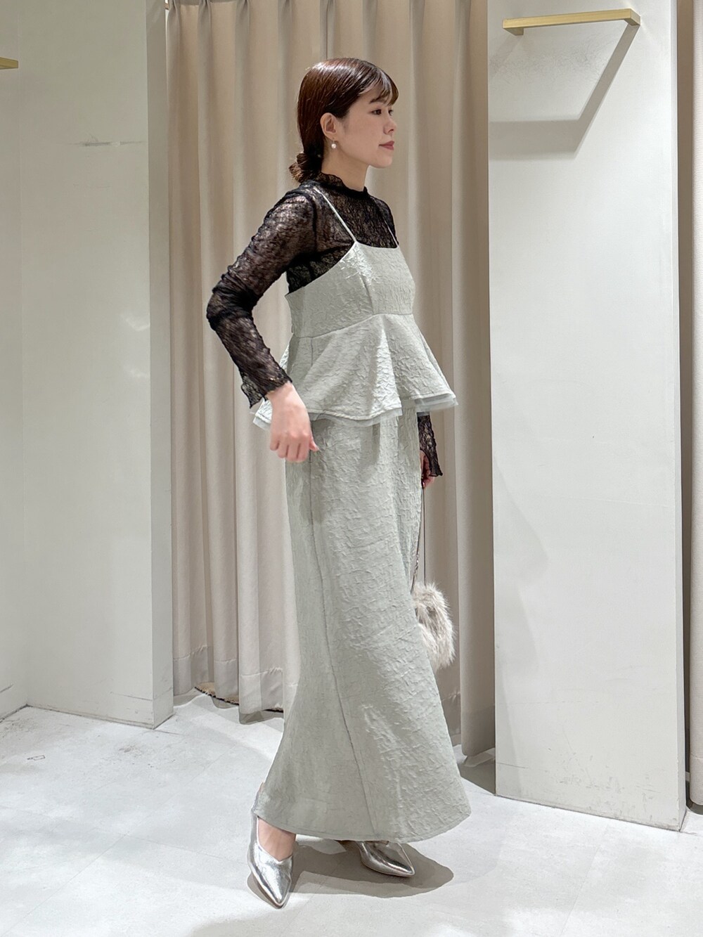 グリーン系のワンピース、ブラック系のTシャツ/カットソー、ベージュ系のショルダーバッグを着用したレディースの冬コーディネートの2枚目の写真