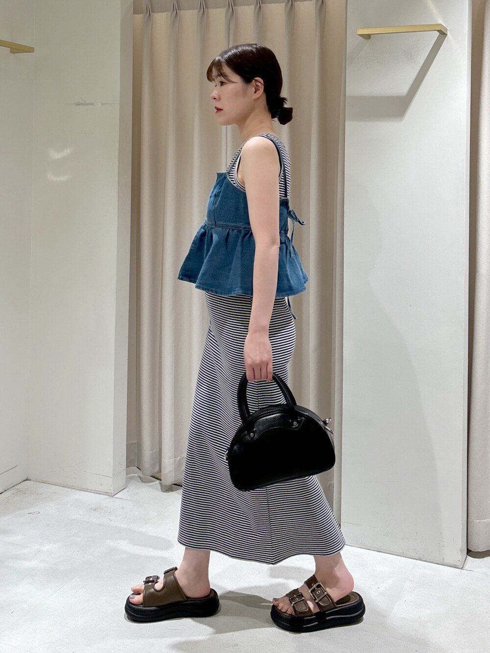 ブルー系のその他トップス、ブルー系のワンピース、ブラック系のトートバッグを着用したレディースの春コーディネートの2枚目の写真