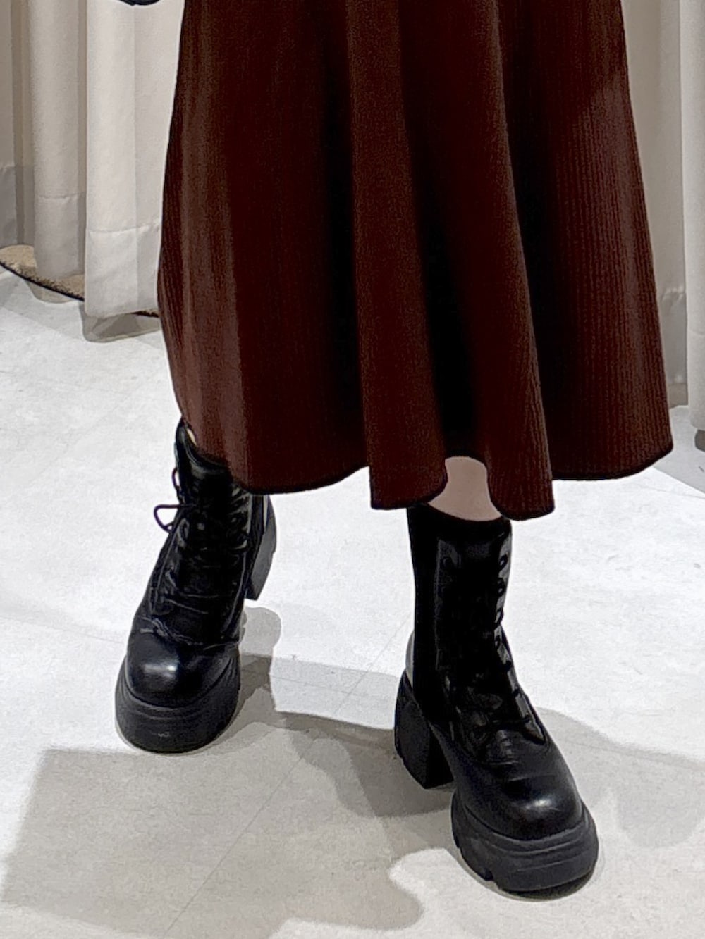 ブラウン系のワンピース、ブラック系のトートバッグ、ブラック系のブーツを着用したレディースの秋コーディネートの5枚目の写真