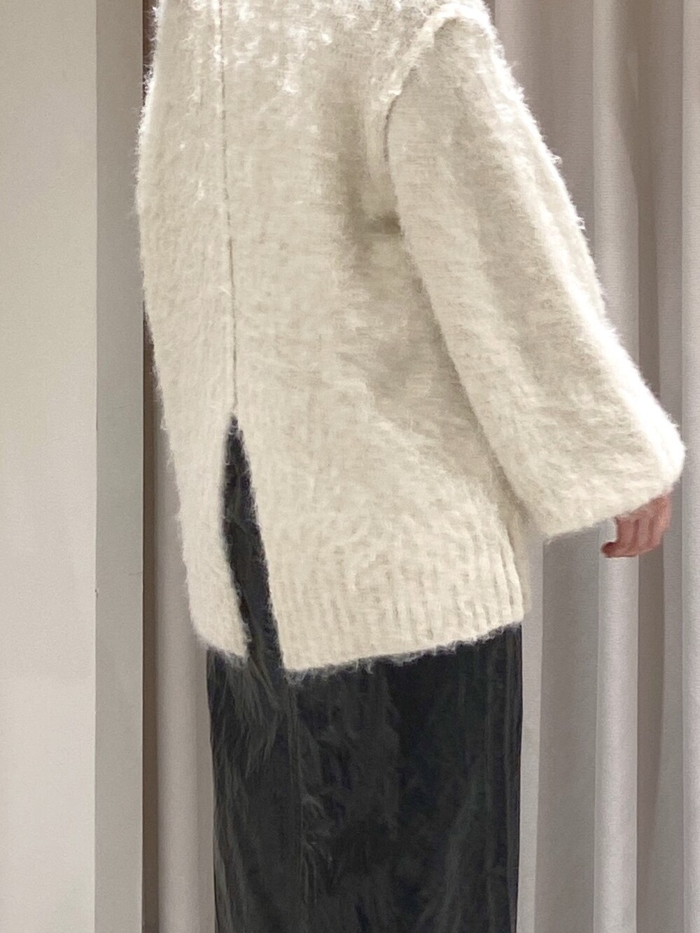 ホワイト系のニット/セーター、ブラック系のTシャツ/カットソー、ブルー系のショルダーバッグを着用したレディースの冬コーディネートの3枚目の写真