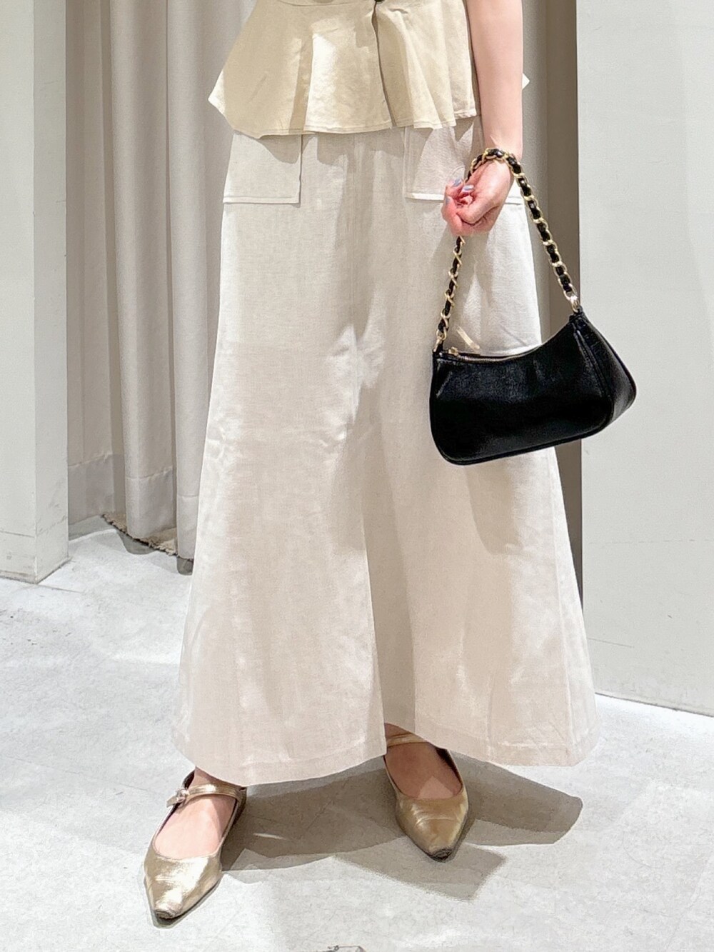 ベージュ系のシャツ/ブラウス、ホワイト系のスカート、ブラック系のトートバッグを着用したレディースの夏コーディネートの4枚目の写真