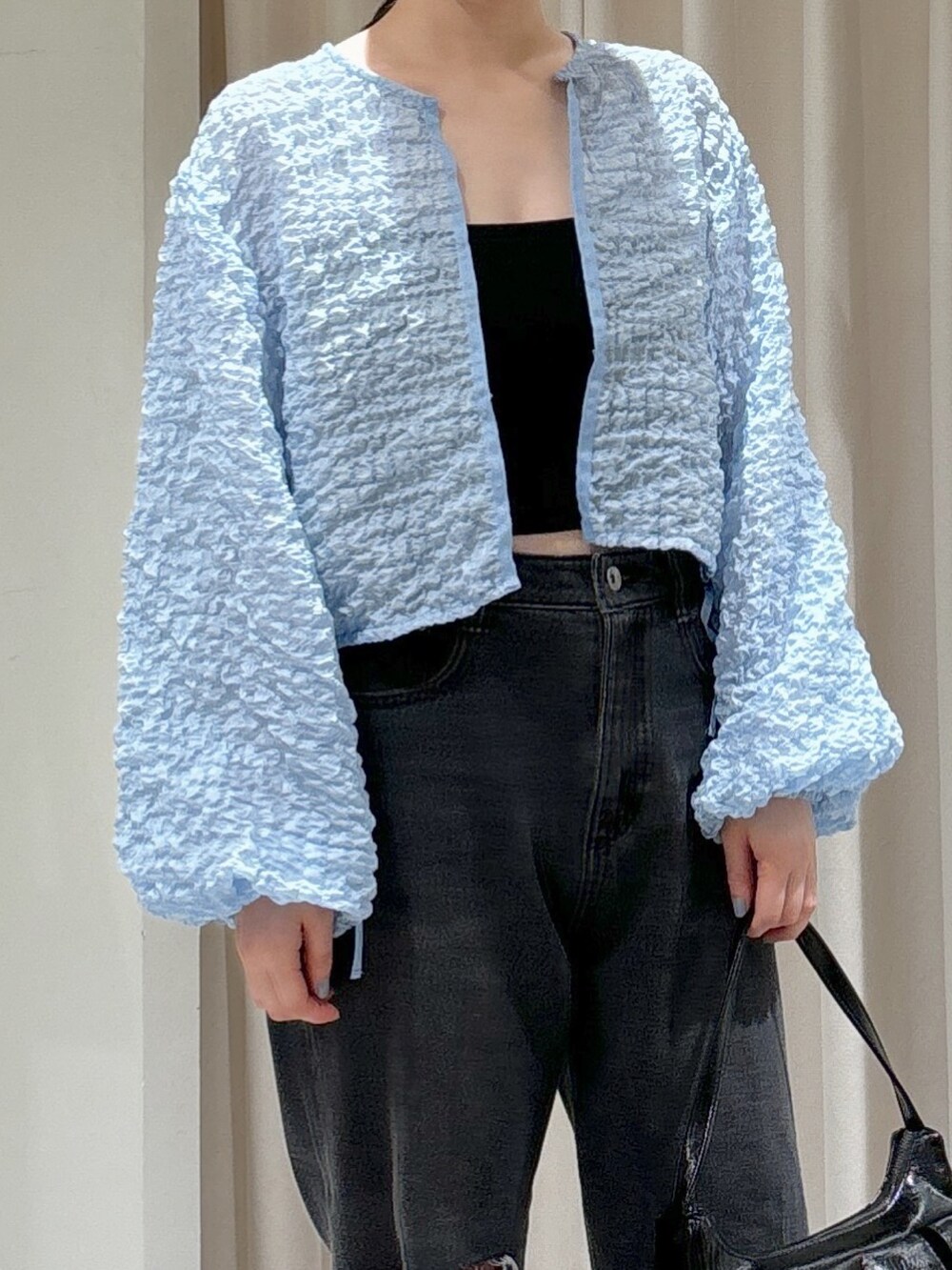 ブルー系のカーディガン/ボレロ、ブラック系のキャミソール、ブラック系のデニムパンツを着用したレディースの夏コーディネートの5枚目の写真