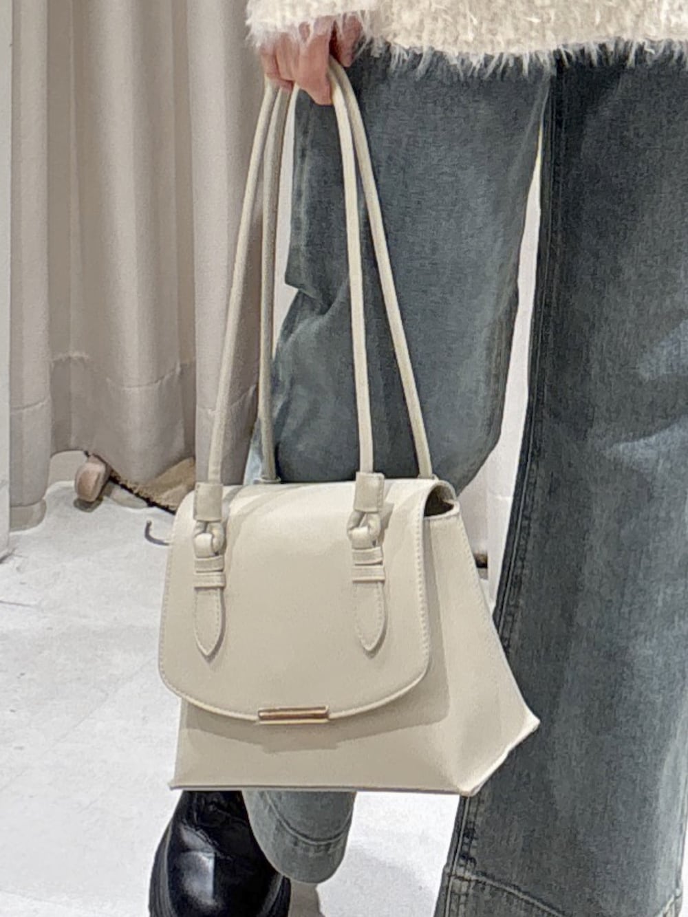 ベージュ系のチェスターコート、ホワイト系のニット/セーター、ホワイト系のショルダーバッグを着用したレディースの冬コーディネートの9枚目の写真