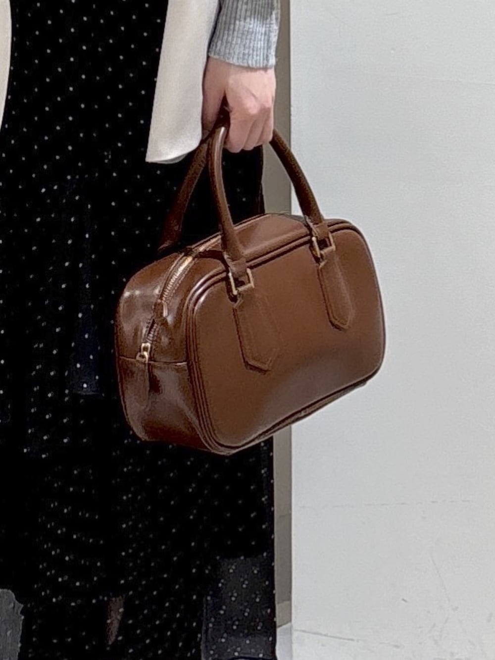 ベージュ系のブルゾン、グレー系のニット/セーター、ブラウン系のハンドバッグを着用したレディースの春コーディネートの7枚目の写真