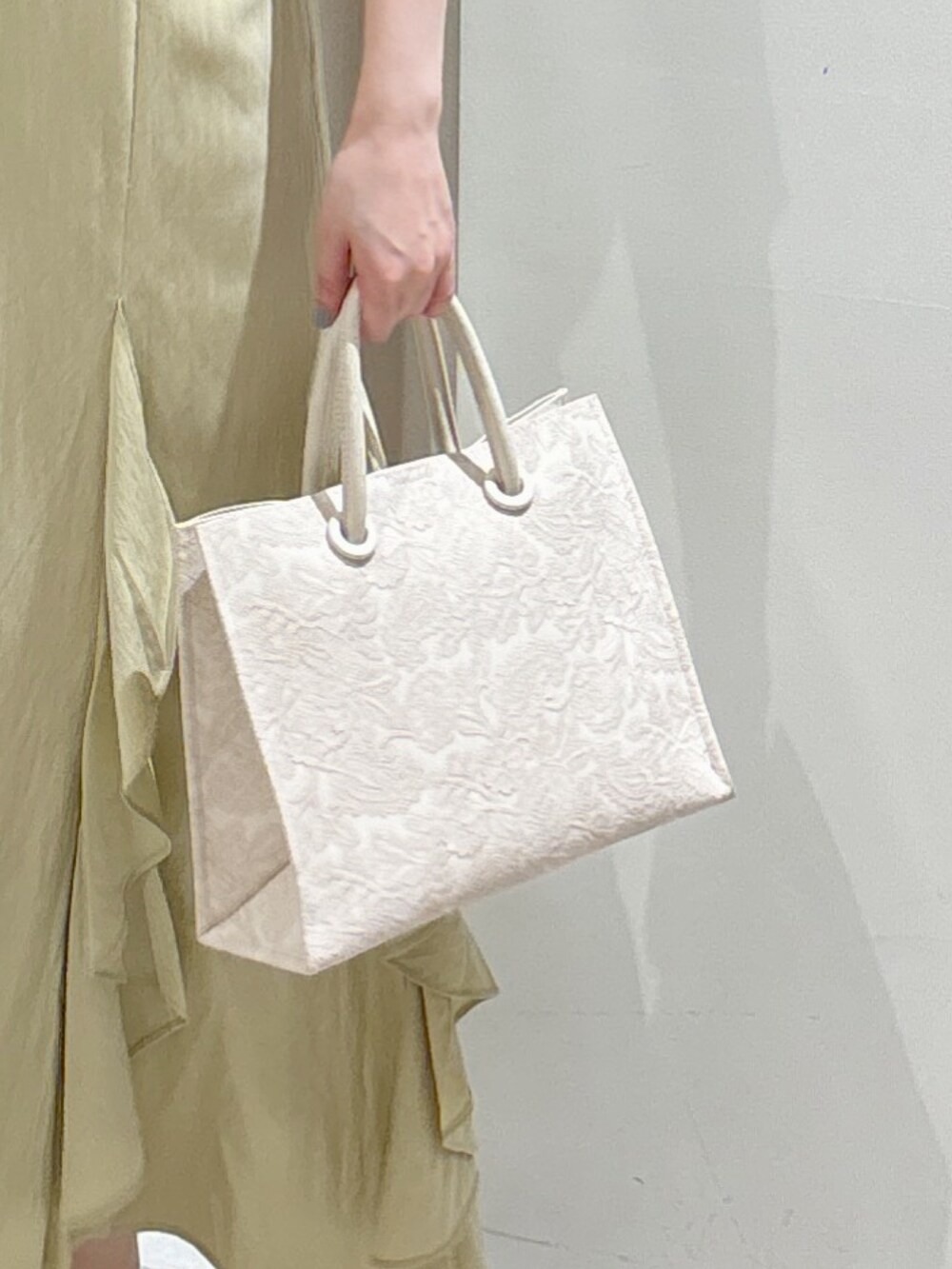 ホワイト系のニット/セーター、イエロー系のスカート、ホワイト系のトートバッグを着用したレディースの春コーディネートの4枚目の写真