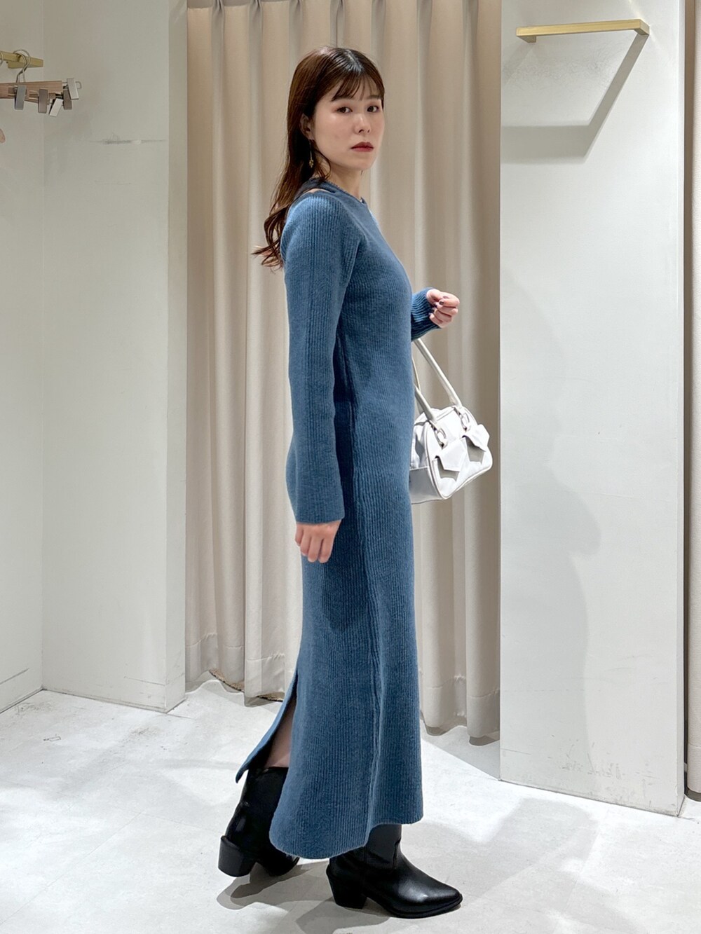 ブルー系のワンピース、ホワイト系のトートバッグ、ブラック系のブーツを着用したレディースの秋コーディネートの2枚目の写真