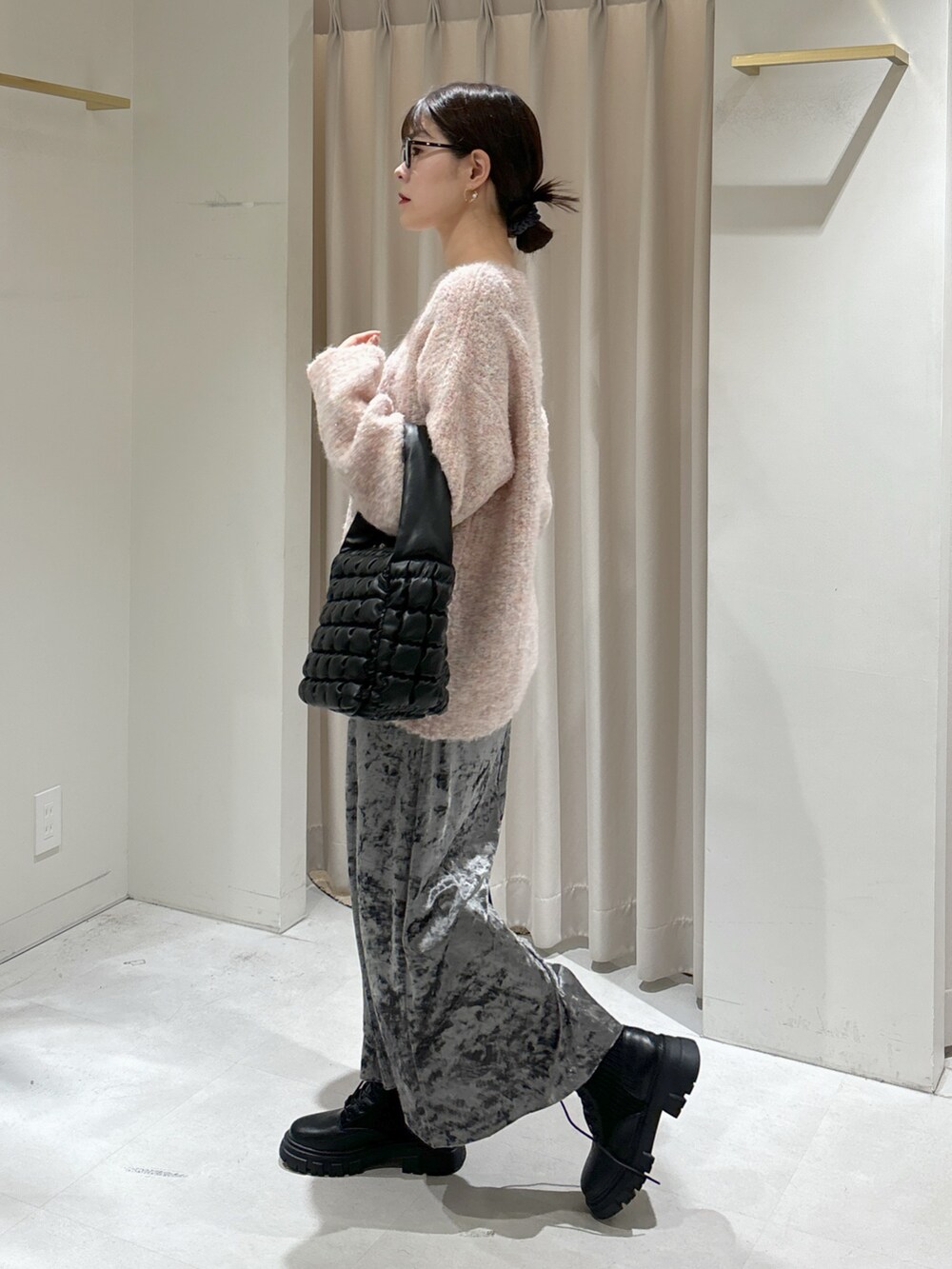 ピンク系のニット/セーター、ブラック系のハンドバッグ、ブラック系のブーツを着用したレディースの秋コーディネートの3枚目の写真