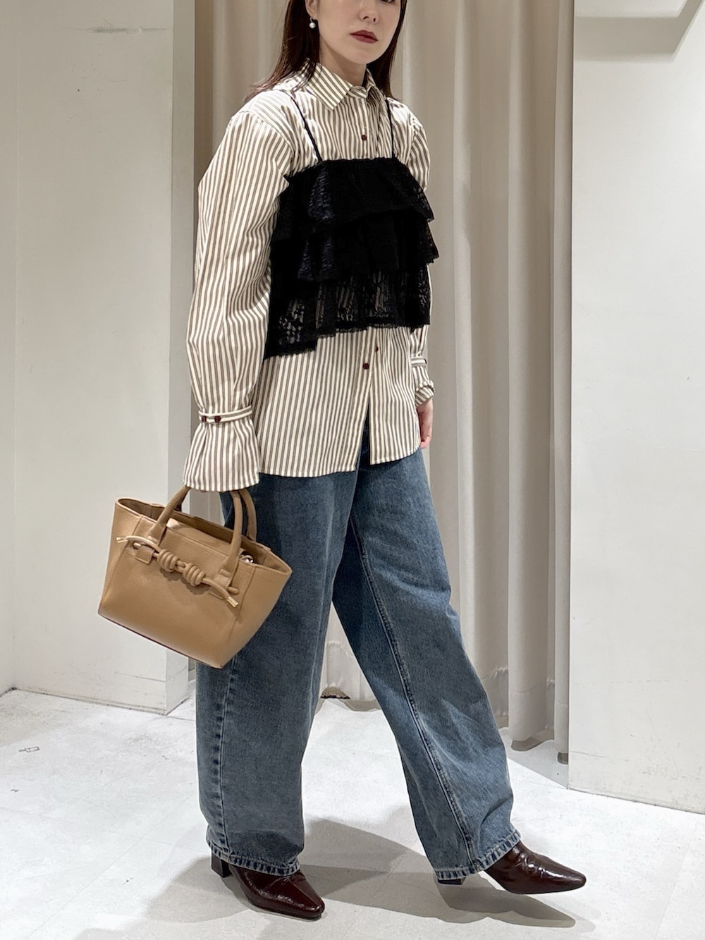 ブラック系のシャツ/ブラウス、ブラウン系のシャツ/ブラウス、ベージュ系のハンドバッグを着用したレディースの冬コーディネートの2枚目の写真