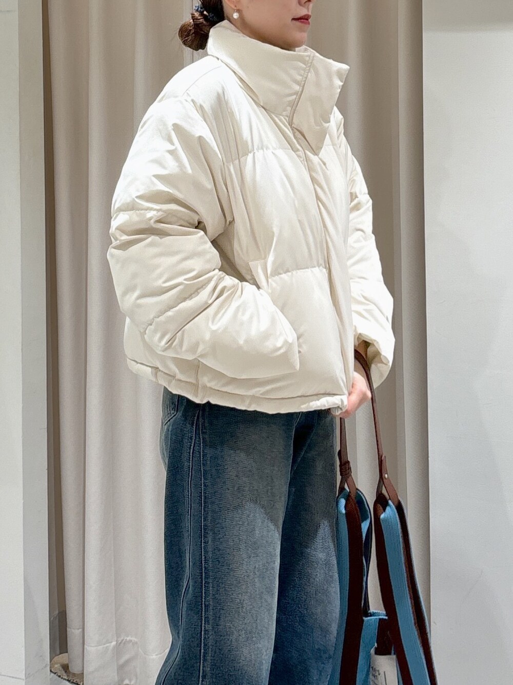 ホワイト系のブルゾン、グリーン系のニット/セーター、ブラウン系のショルダーバッグを着用したレディースの冬コーディネートの6枚目の写真