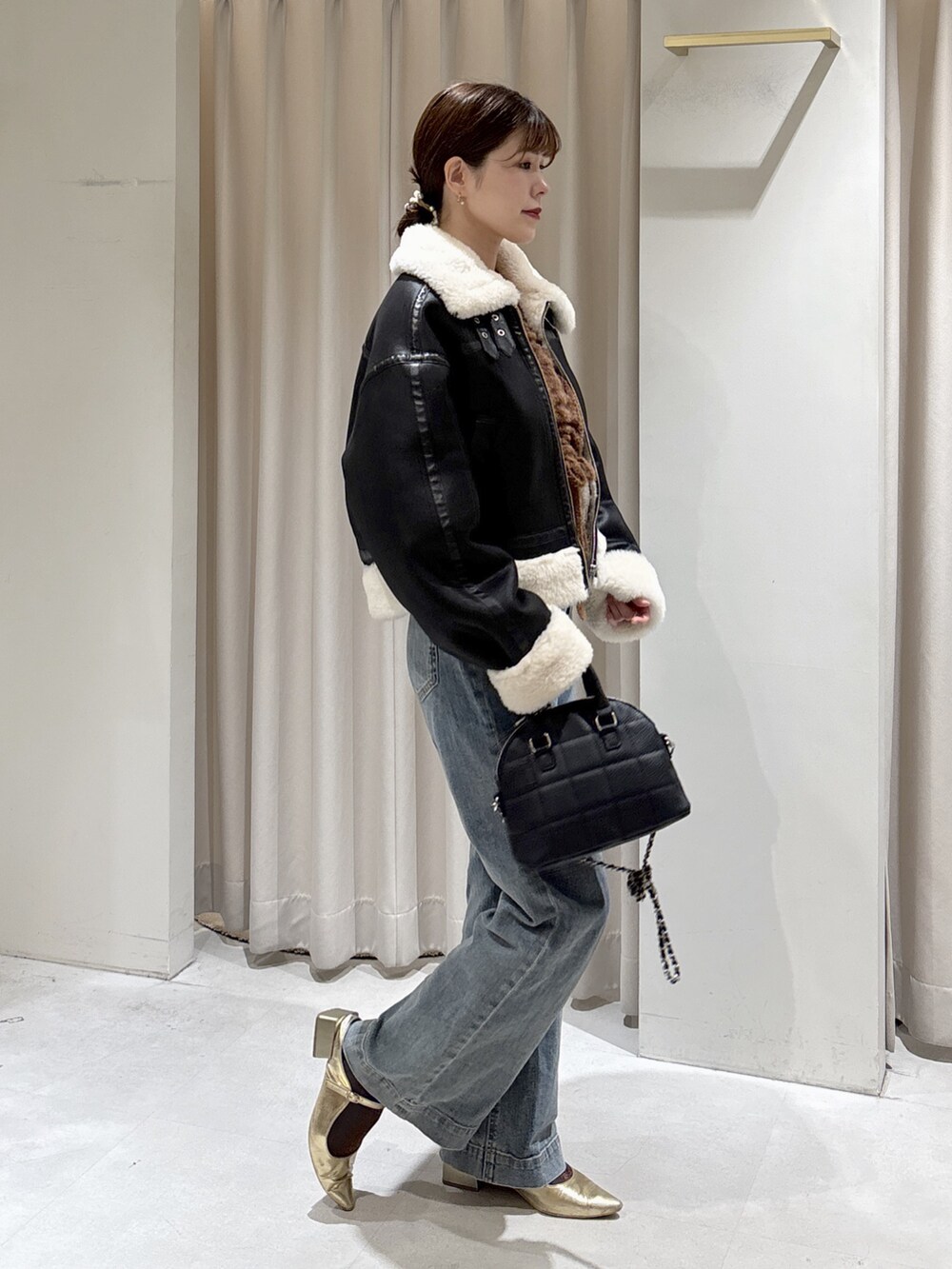 ブラック系のブルゾン、ブラック系のトートバッグ、ブラウン系のニット/セーターを着用したレディースの秋コーディネートの3枚目の写真