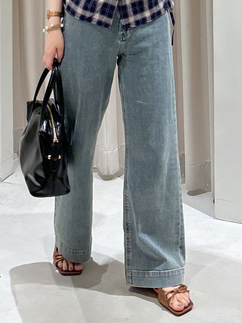 ブルー系のシャツ/ブラウス、ブルー系のデニムパンツ、ブラック系のボストンバッグを着用したレディースの夏コーディネートの3枚目の写真