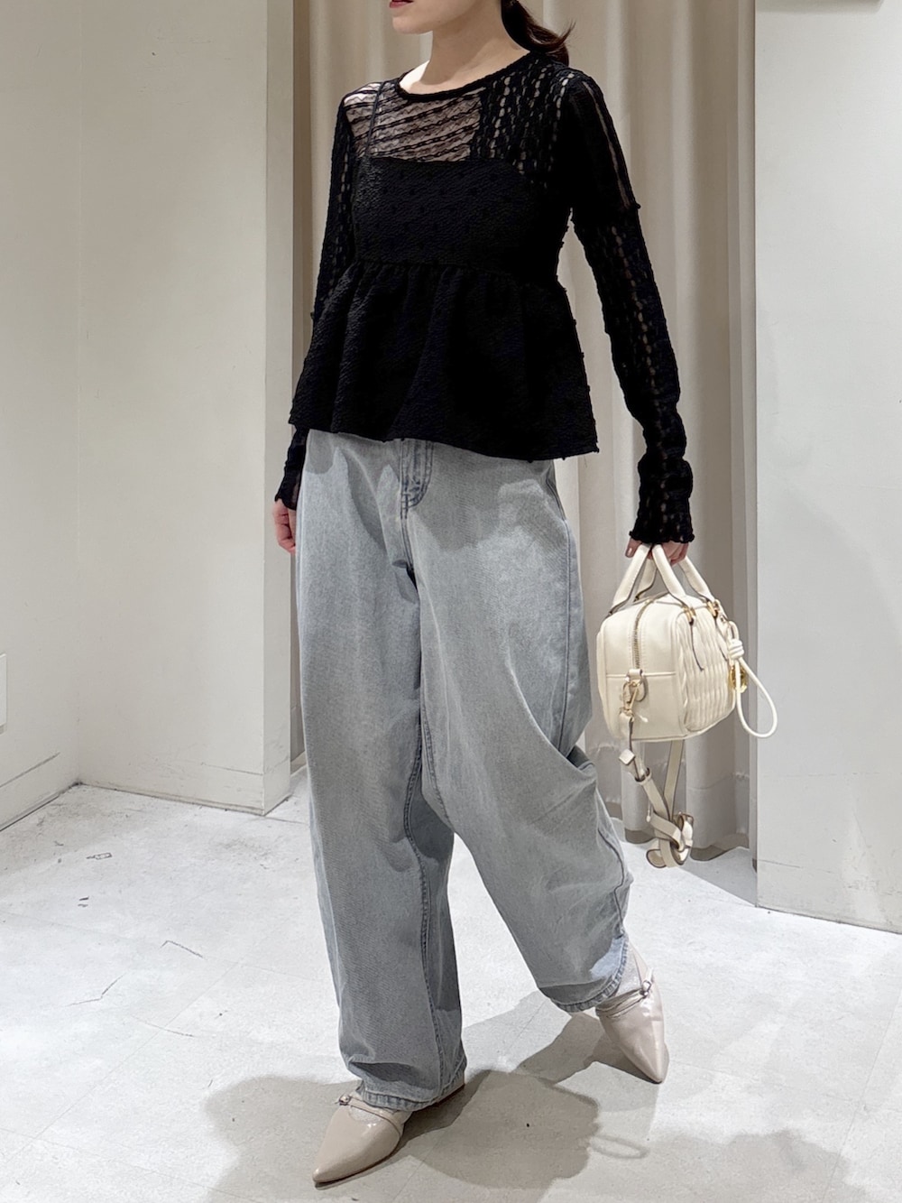 ブラック系のシャツ/ブラウス、ブラック系のTシャツ/カットソー、ホワイト系のボストンバッグを着用したレディースの春コーディネートの2枚目の写真