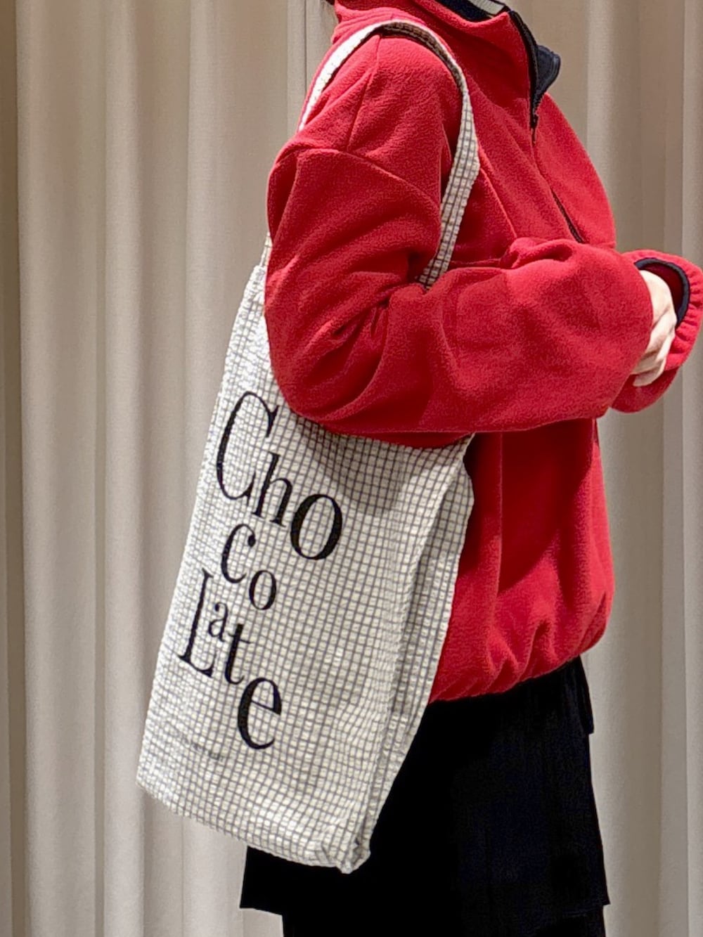 レッド系のスウェット、ホワイト系のニット/セーター、ブラック系のトートバッグを着用したレディースの秋コーディネートの6枚目の写真