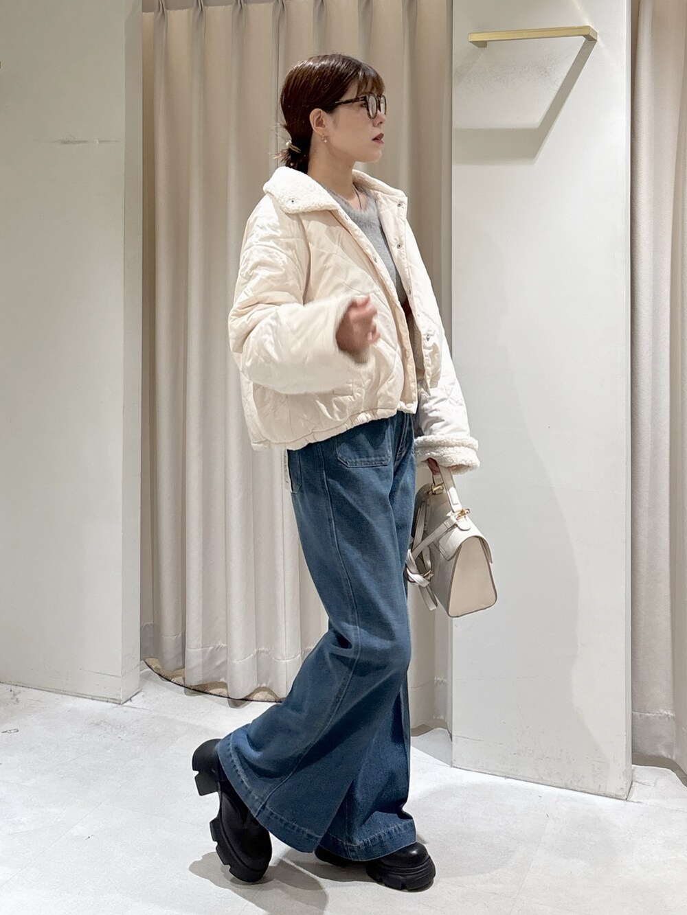 グレー系のニット/セーター、ブルー系のデニムパンツ、ホワイト系のトートバッグを着用したレディースの秋コーディネートの10枚目の写真