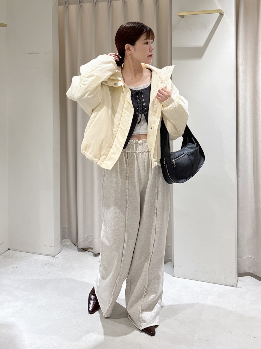 ブラック系のTシャツ/カットソー、ホワイト系のスウェットパンツ、ブラック系のハンドバッグを着用したレディースの秋コーディネートの4枚目の写真