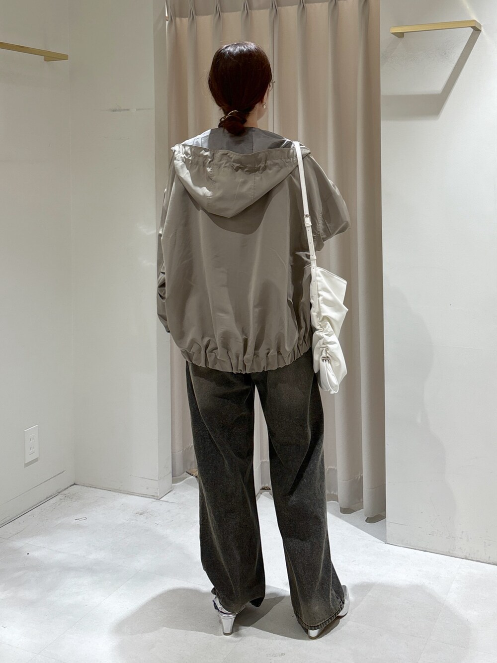 グリーン系のマウンテンパーカー、ブラック系のTシャツ/カットソー、ホワイト系のキャミソールを着用したレディースの冬コーディネートの4枚目の写真