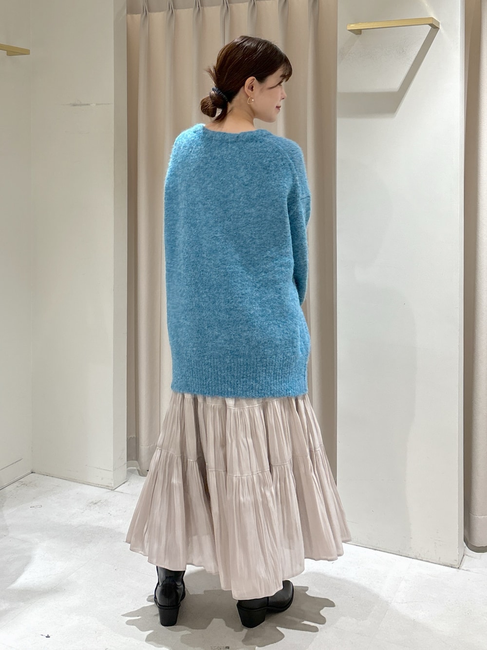 ブルー系のカーディガン/ボレロ、ブラック系のキャミソール、ホワイト系のスカートを着用したレディースの秋コーディネートの3枚目の写真