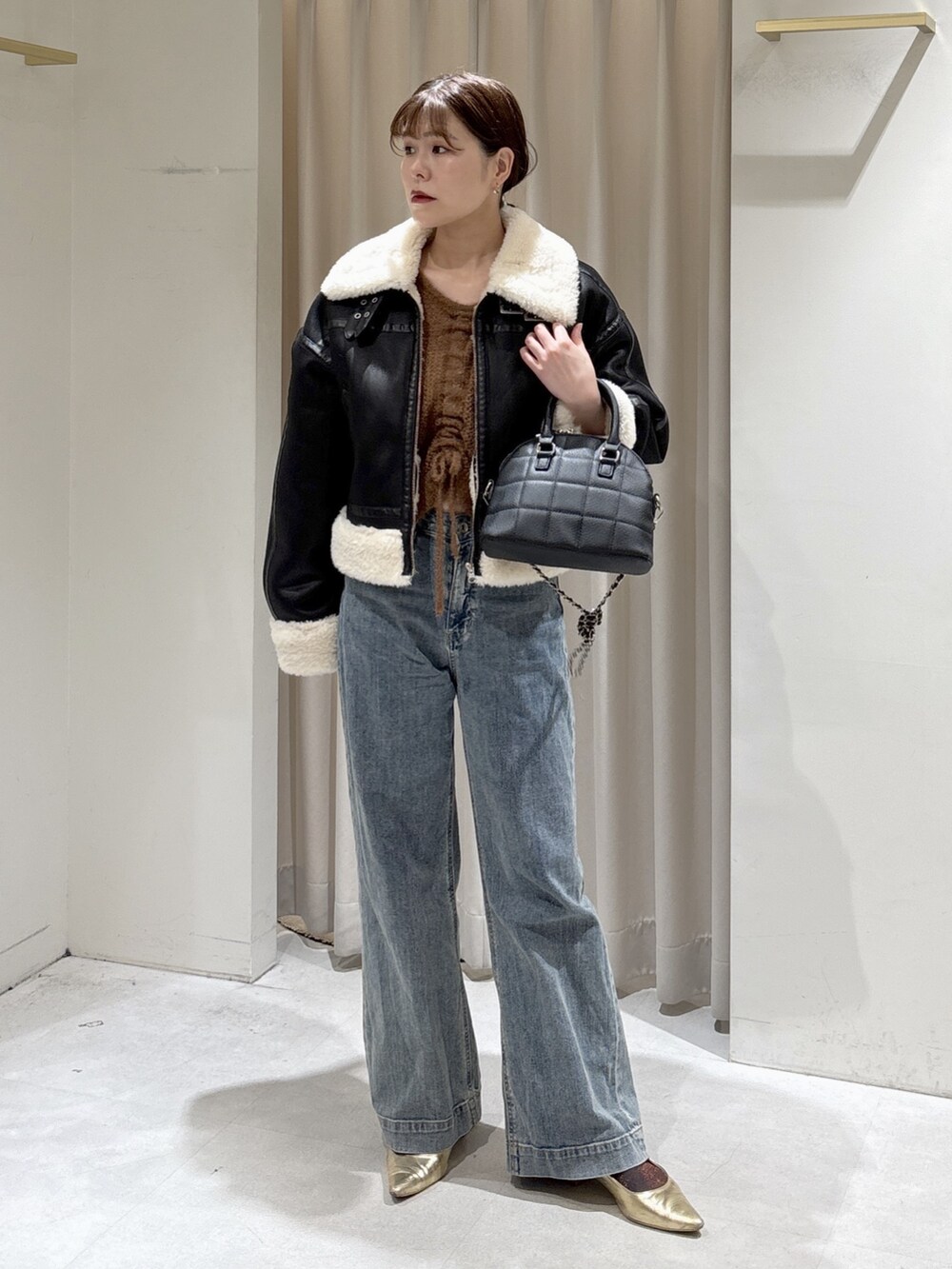 ブラウン系のニット/セーター、ブルー系のデニムパンツ、ブラック系のトートバッグを着用したレディースの秋コーディネートの3枚目の写真