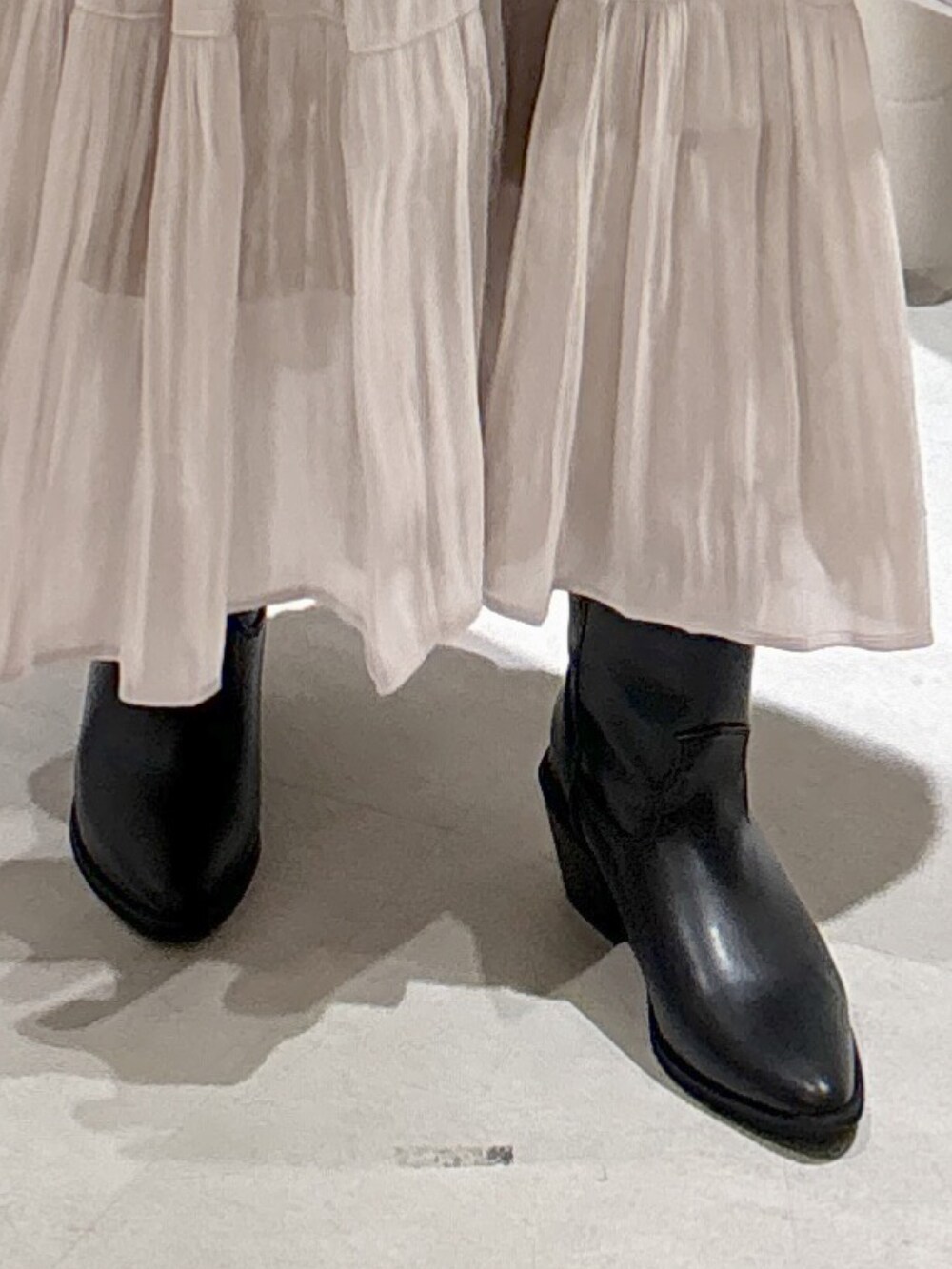 ブルー系のカーディガン/ボレロ、ブラック系のキャミソール、ホワイト系のスカートを着用したレディースの秋コーディネートの8枚目の写真