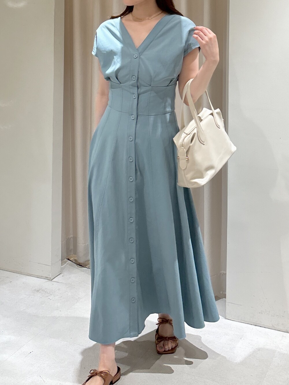 ブルー系のワンピース、ホワイト系のボストンバッグ、ブラウン系のサンダルを着用したレディースの夏コーディネートの2枚目の写真