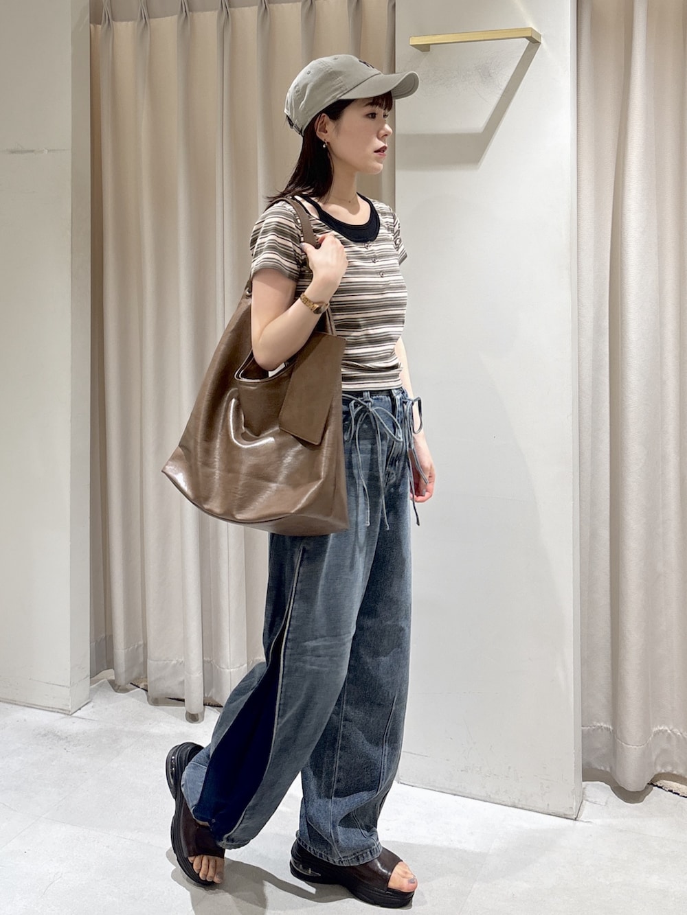 ブラウン系のTシャツ/カットソー、ブルー系のデニムパンツ、ブラウン系のトートバッグを着用したレディースの夏コーディネートの3枚目の写真