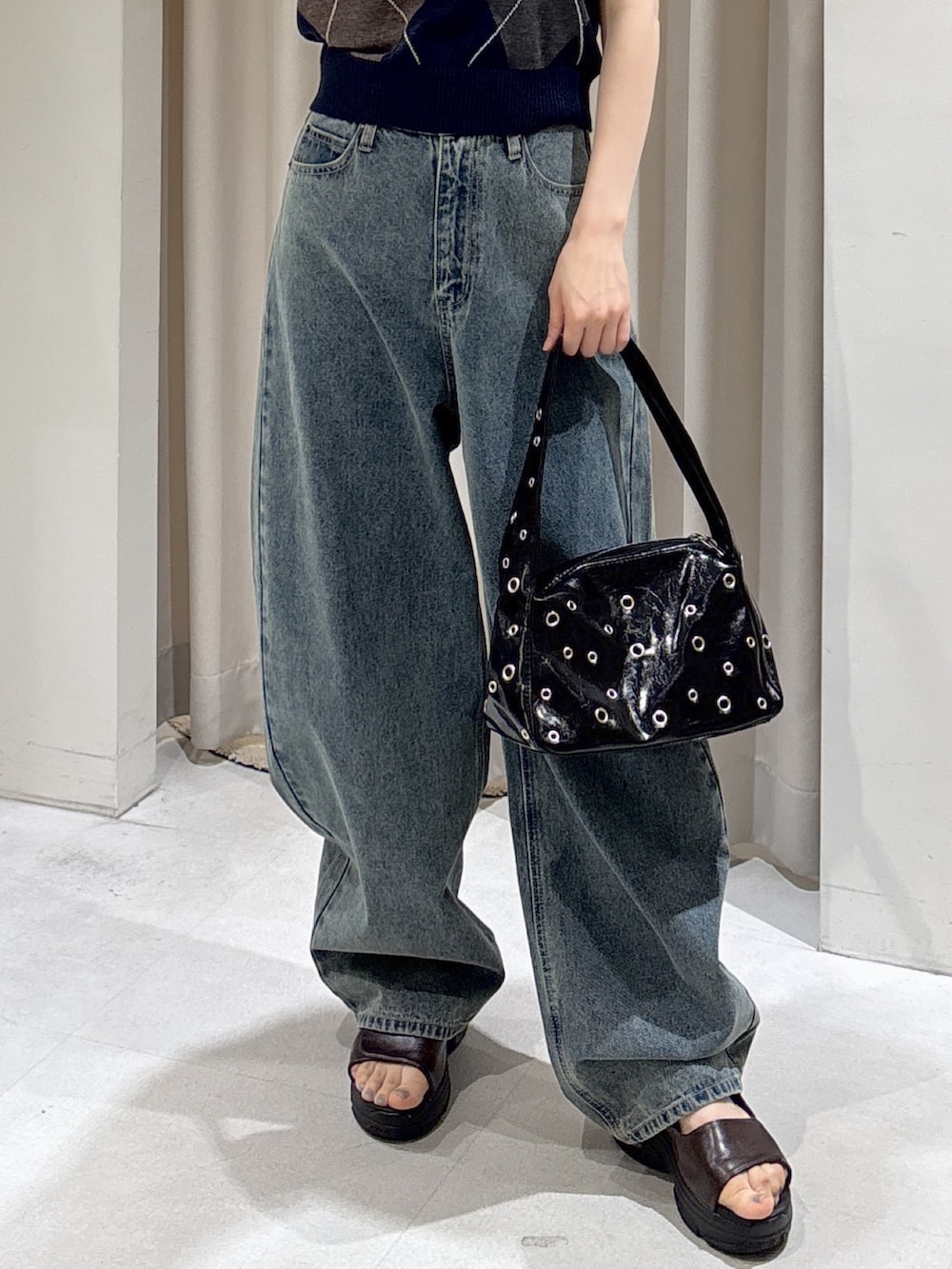 ブルー系のニット/セーター、ブルー系のデニムパンツ、ブラック系のショルダーバッグを着用したレディースの夏コーディネートの5枚目の写真