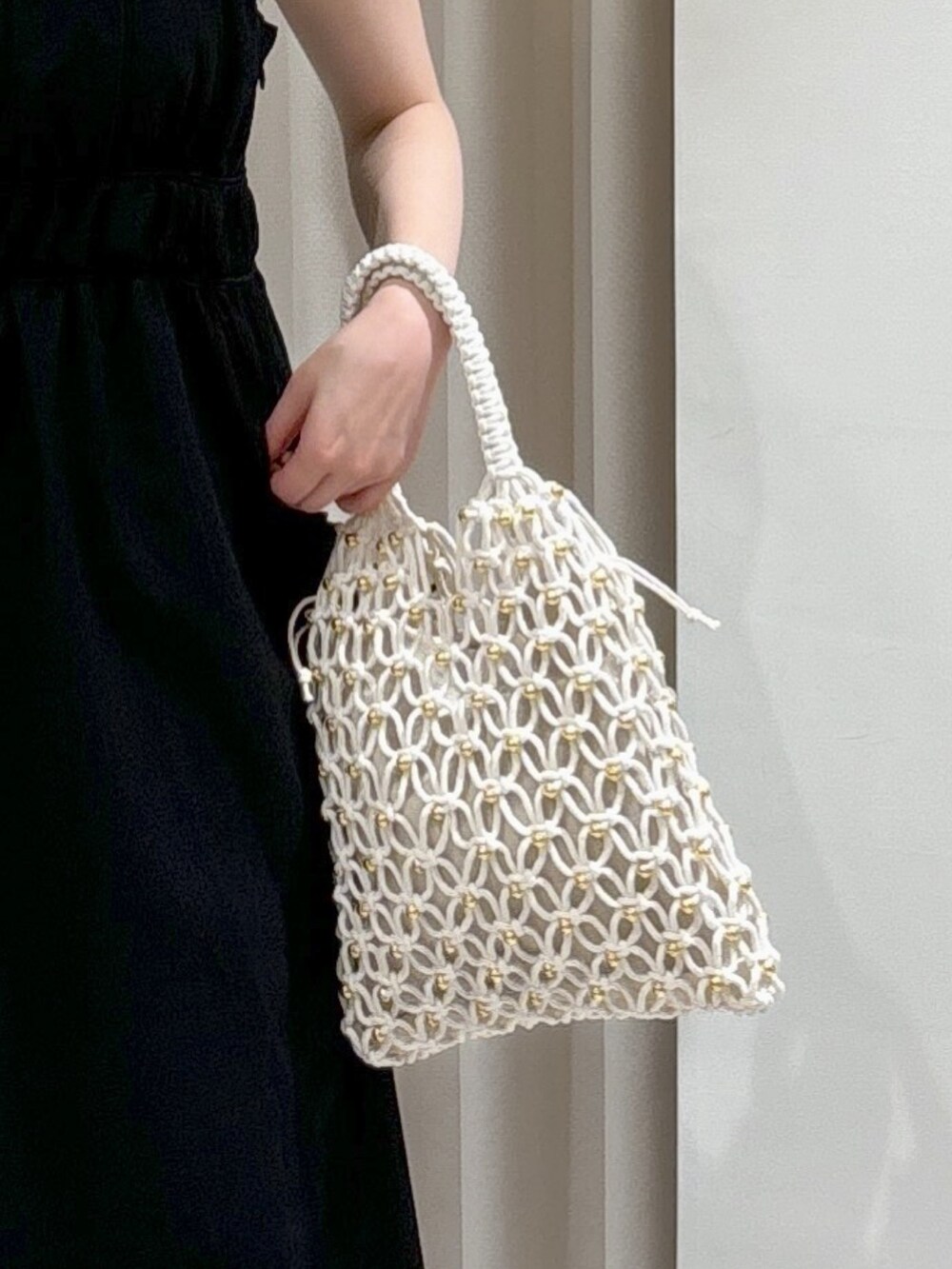 ブラック系のワンピース、グレー系のサンダル、ホワイト系のハンドバッグを着用したレディースの春コーディネートの4枚目の写真