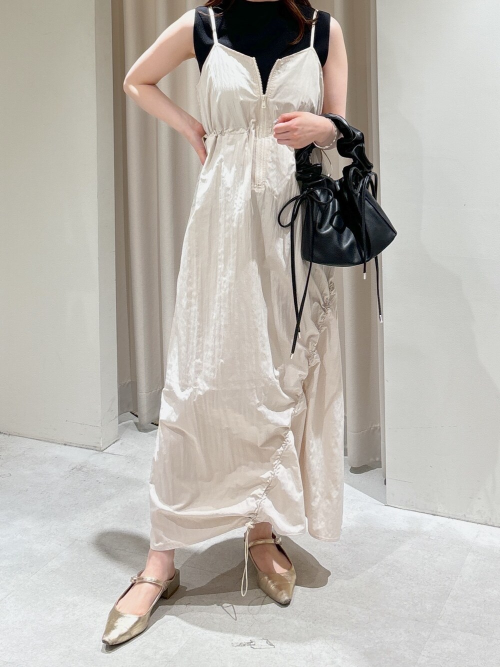 ホワイト系のワンピース、ブラック系のショルダーバッグ、ブラック系のニット/セーターを着用したレディースの春コーディネートの3枚目の写真