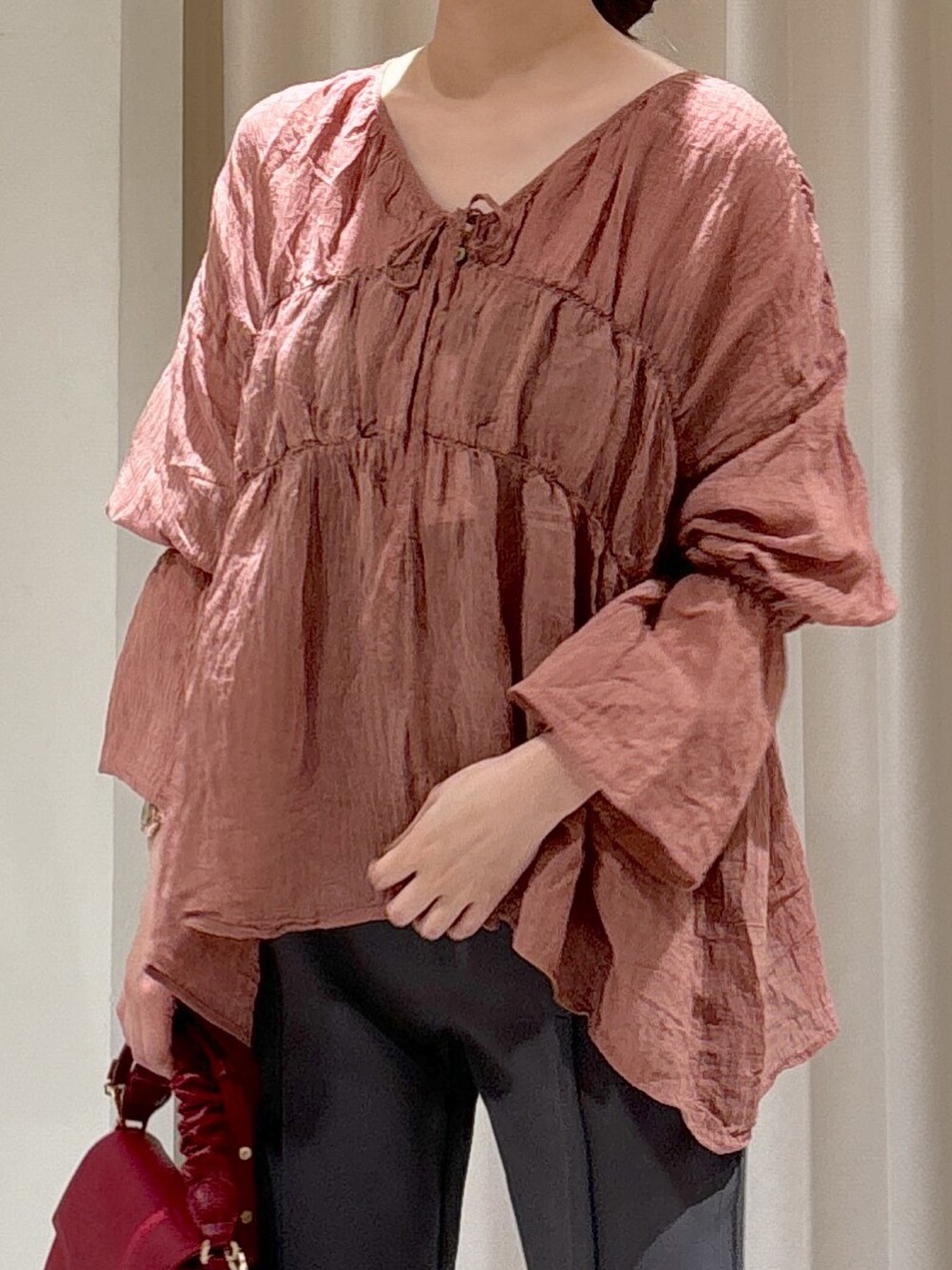 ブラック系のシャツ/ブラウス、レッド系のショルダーバッグ、グレー系のスラックスを着用したレディースの秋コーディネートの4枚目の写真