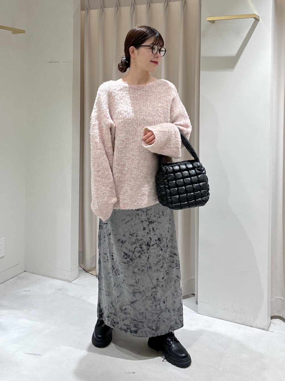 ピンク系のニット/セーター、ブラック系のハンドバッグ、ブラック系のブーツを着用したレディースの秋コーディネートの7枚目の写真