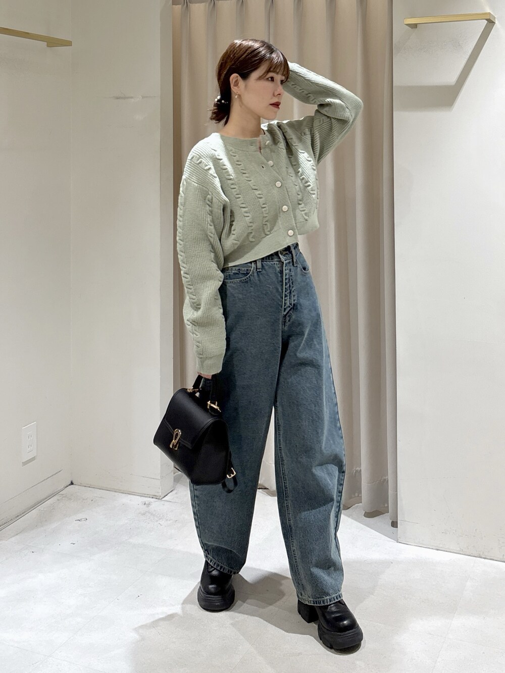 グリーン系のワンピース、ブルー系のデニムパンツ、ブラック系のトートバッグを着用したレディースの冬コーディネートの8枚目の写真