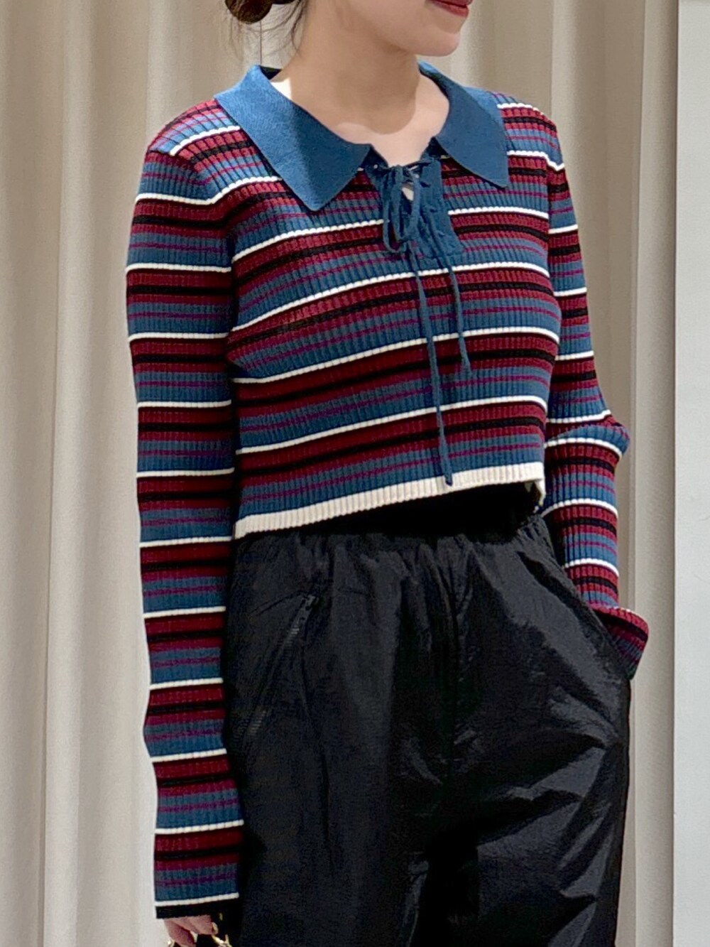 ブルー系のニット/セーター、ブラック系のトートバッグ、ベージュ系のブーツを着用したレディースの秋コーディネートの2枚目の写真