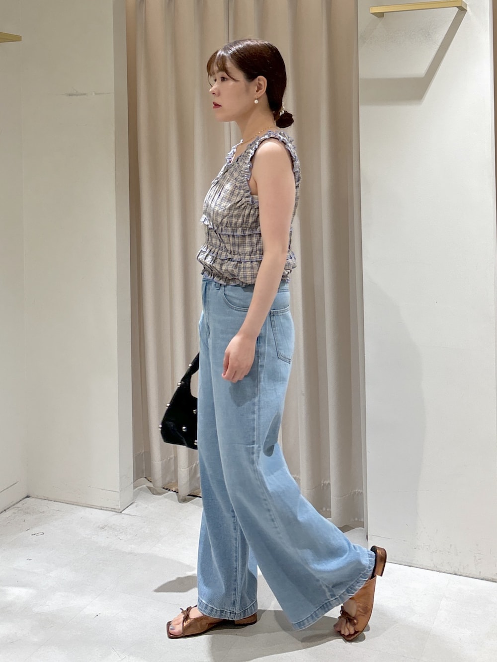 レッド系のシャツ/ブラウス、ブルー系のデニムパンツ、ブラック系のハンドバッグを着用したレディースの夏コーディネートの3枚目の写真